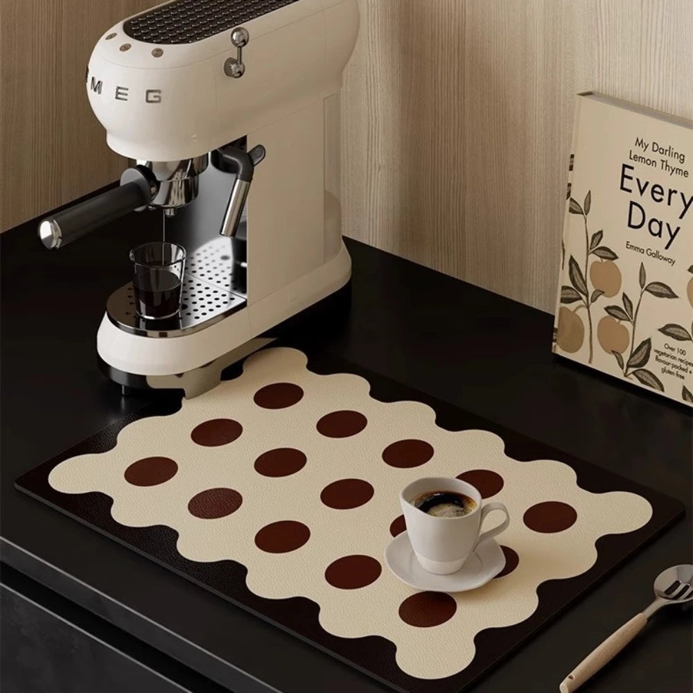 White Smeg espresso machine on a dark surface with a polka dot placemat and a cup of coffee.