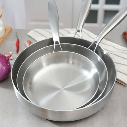 Set of stainless steel frying pans on a kitchen counter with Seasona branding.